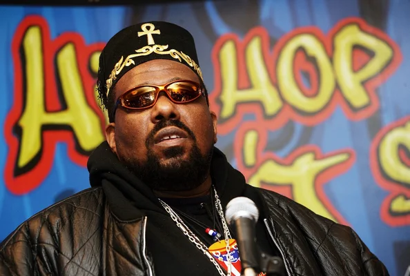 Afrika Bambaataa s'exprimant au micro lors d'un événement public.