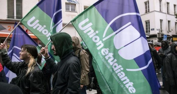 Membres d'Union étudiante en manifestation avec des drapeaux à l'effigie de leur syndicat.