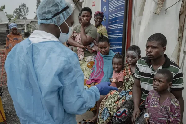 Personnel de santé en tenue bleue échangeant avec des patientes en RDC.