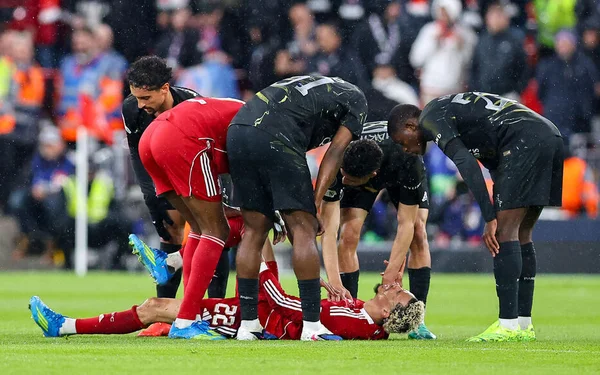 Hugo Ekitiké au sol, entouré de joueurs préoccupés lors de la rencontre Liverpool-PSG.
