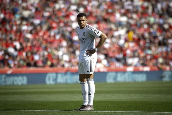 Kylian Mbappé en tenue du Real Madrid les mains sur les hanches.