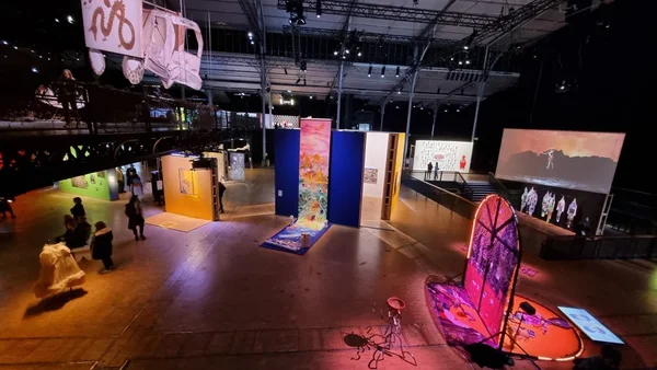 L'effervescence des visiteurs et la diversité des œuvres lors de l'exposition 100% L'EXPO à la Grande Halle de la Villette.