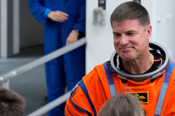 Gros plan sur Jeremy Hansen en combinaison spatiale orange lors d'une préparation.