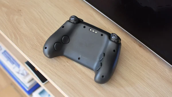 Le Steam Controller de Valve posé sur une table en bois.