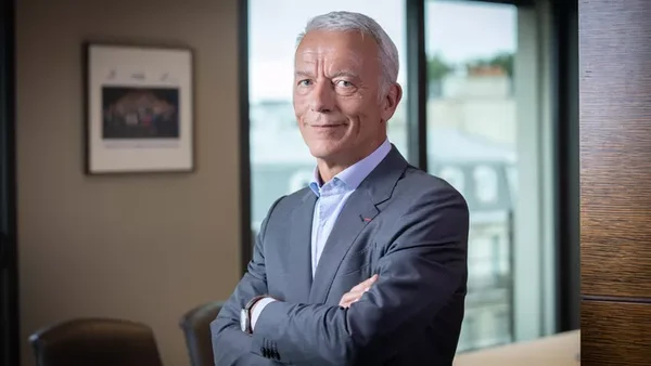 Patrick Martin, patron du Medef, en costume gris dans un bureau.