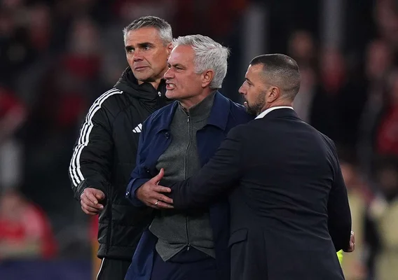 José Mourinho discutant avec des interlocuteurs lors d'un événement nocturne.