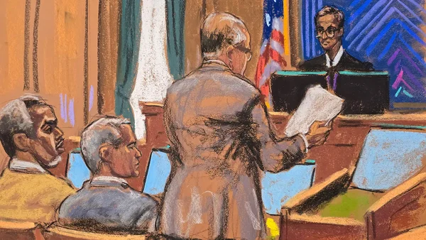 Sean 'Diddy' Combs lors de son procès, vêtu d'une veste blanche et d'une chemise claire.