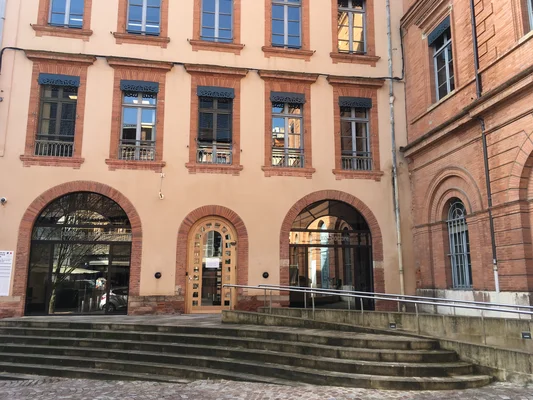 Le palais de justice de Montauban, un bâtiment en briques rouges et de couleur pêche.