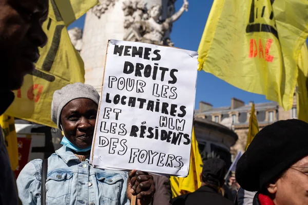 Un homme tient une pancarte revendiquant l'égalité des droits pour les locataires et résidents de foyers.