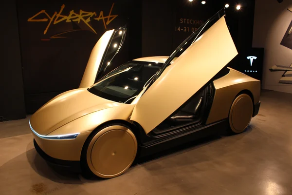 Vue du Tesla Cybercab avec ses portes ouvertes dans un environnement sombre.