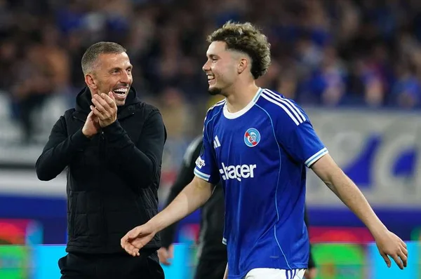 Matias Fernandez-Pardo échangeant avec un membre du staff dans un stade.