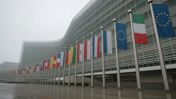 Drapeaux des pays membres de l'Union européenne alignés devant le bâtiment du Conseil de l'UE à Bruxelles, ciel gris, vue en contre-plongée