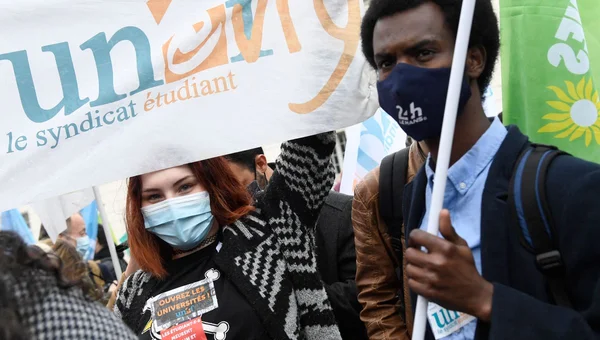 Manifestants avec une banderole syndicale étudiante lors d'un rassemblement.