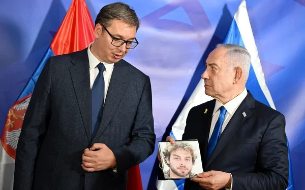 Deux responsables en costume lors d'une rencontre officielle devant des drapeaux, illustrant la coopération.