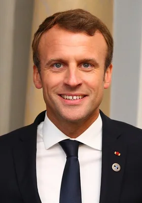 Portrait d'Emmanuel Macron en costume sombre et cravate bleue.