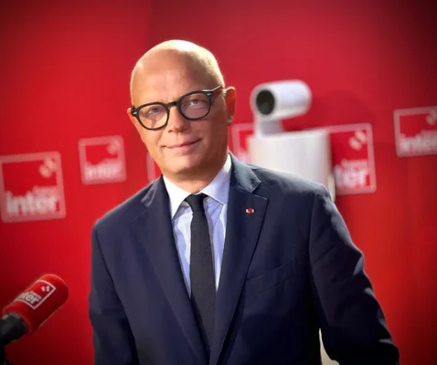 Édouard Philippe posant devant un fond rouge lors d'une interview à la radio