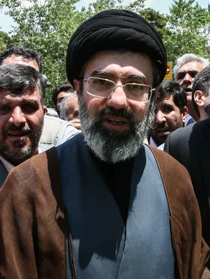Portrait de Mojtaba Khamenei, le nouveau guide suprême iranien, barbe grise et lunettes.
