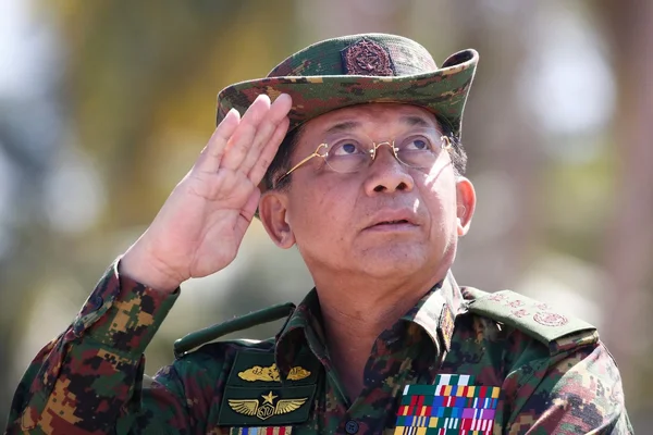 Le général Min Aung Hlaing, chef de la junte, en uniforme militaire faisant le salut.