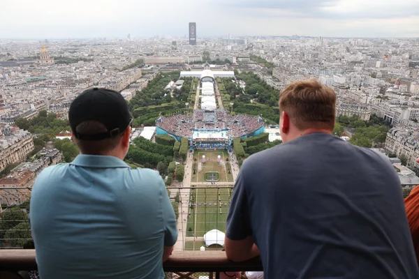 Des visiteurs profitant de la vue sur le stade de beach-volley des JO Paris 2024 depuis la tour Eiffel.