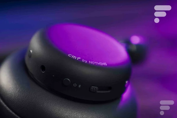 Détail de l'écouteur du casque CMF by Nothing sous un éclairage violet.