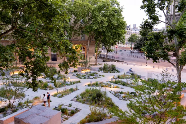 Le Jardin mémoriel des attentats du 13 novembre 2015, un parc urbain géométrique avec des visiteurs.