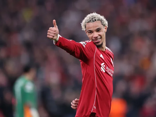 Hugo Ekitike levant son maillot Liverpool dos à la caméra.