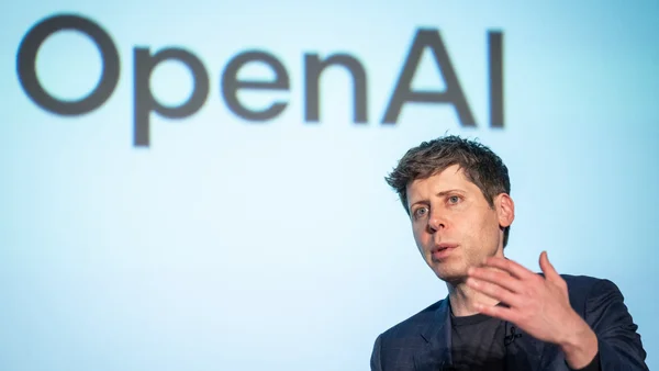 Un conférencier devant le logo OpenAI lors d'une présentation liée aux nouveaux abonnements de l'entreprise.
