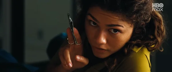 Une scène de la série montrant Zendaya en haut jaune tenant des billets de banque.