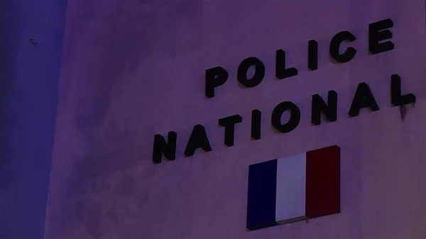 Inscription 'POLICE NATIONALE' sur un mur officiel.