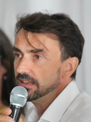 Grégory Doucet, maire sortant de Lyon, posant devant un fond avec inscription lors du lancement de sa campagne