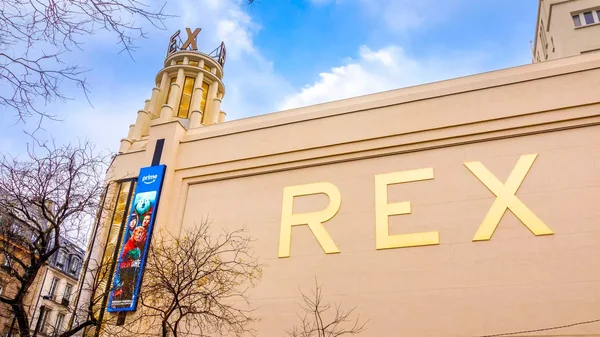 L'entrée du cinéma Le Grand Rex et sa tour distinctive sur un boulevard parisien.