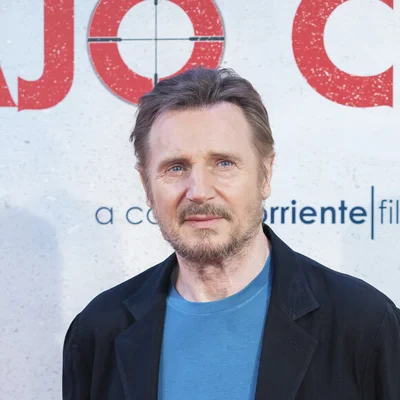 L'acteur Liam Neeson posant devant un fond texturé.