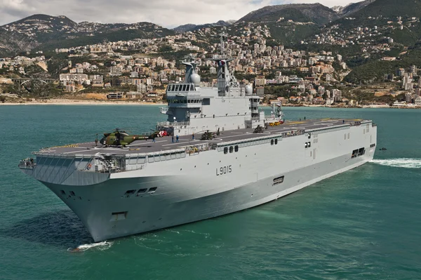 Le navire amphibie Dixmude (L9015) dans la baie de Jounieh au Liban, un hélicoptère stationné sur son pont d'envol.