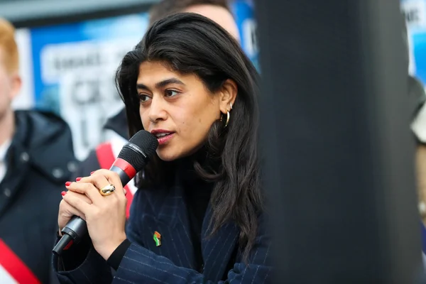 Rima Hassan s'exprimant devant un podium de micros lors d'une conférence de presse.