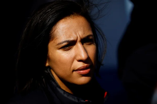 Portrait d'une personne aux cheveux noirs portant une veste sombre.