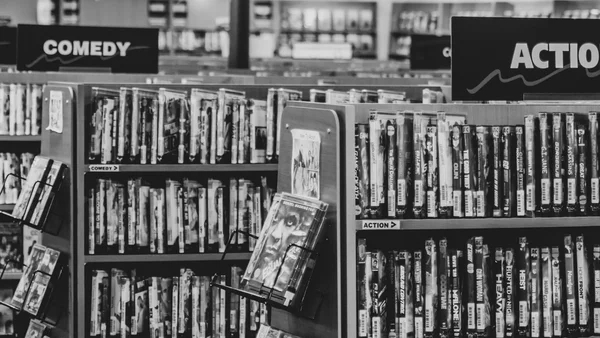 Rayonnages de DVD dans un magasin, illustrant les sections Comédie et Action.