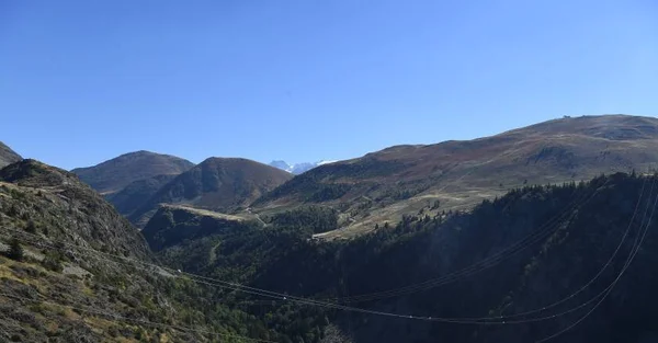 Le paysage accidenté des Alpes-de-Haute-Provence avec des lignes électriques traversant la vallée.