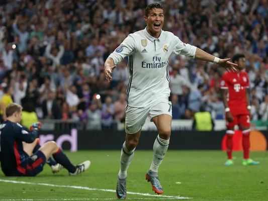 Joueur du Real Madrid célébrant face au gardien du Bayern et au public.