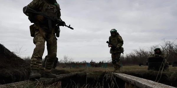 Des soldats ukrainiens progressent sur un terrain d'entraînement tactique.