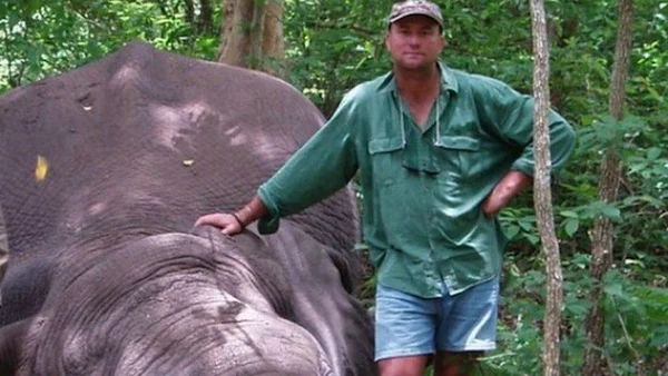 Un chasseur au Zimbabwe posant avec un éléphant avant l'accident tragique.