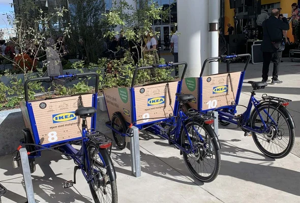Vélos-cargos IKEA bleus équipés de cartons pour le transport.