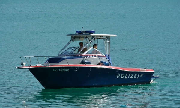 Un bateau de la police fluviale, immatriculé O-10546, naviguant sur une eau calme.