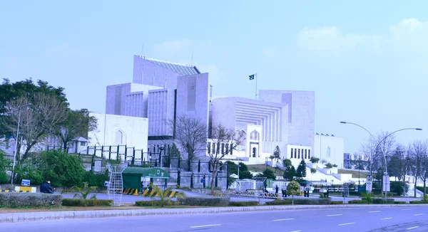 Le bâtiment de la Cour suprême du Pakistan à Islamabad, avec son architecture moderne en blanc et son drapeau national.
