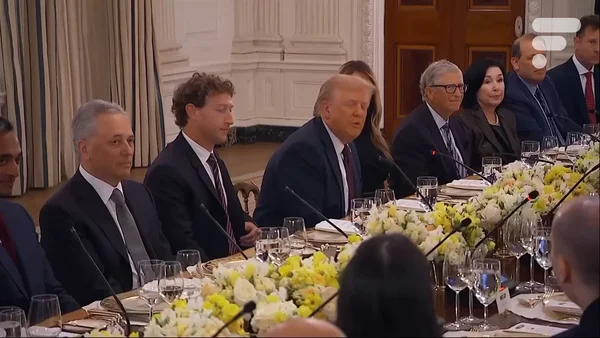 Un groupe de dirigeants de la tech en tenue de soirée réunis autour d'une table lors d'un dîner formel.