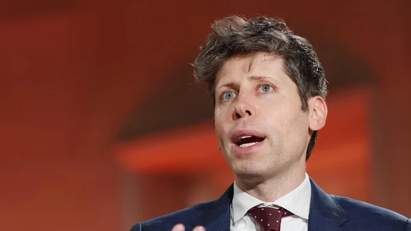 Portrait officiel de Sam Altman en costume et cravate.