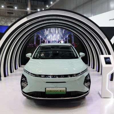 L'OMODA EV exposé sous un éclairage architectural moderne lors d'un salon automobile.