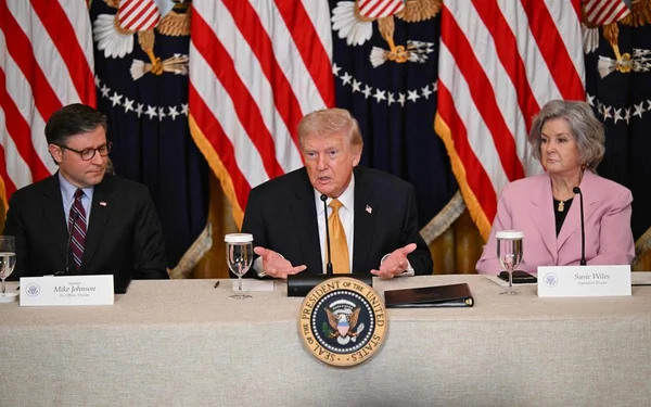 Donald Trump accompagné de Mike Johnson et Susie Wiles lors d'une déclaration officielle.