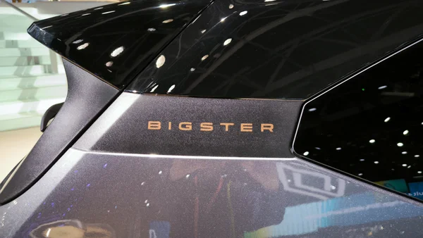 Détail du lettrage doré 'BIGSTER' à l'arrière du véhicule exposé au Mondial de l'automobile.