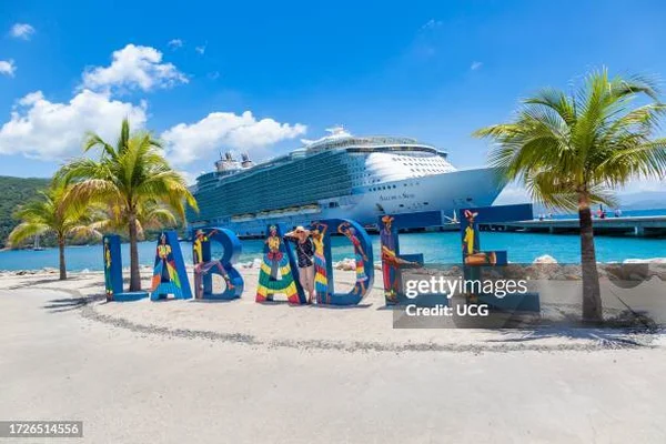 Un navire de croisière amarré au port de Labadee, avec des palmiers et les lettres 'LABADEE' en premier plan.