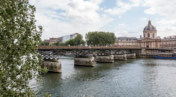 Une passante traversant le Pont des Arts après sa rénovation, avec l'Institut de France en arrière-plan.